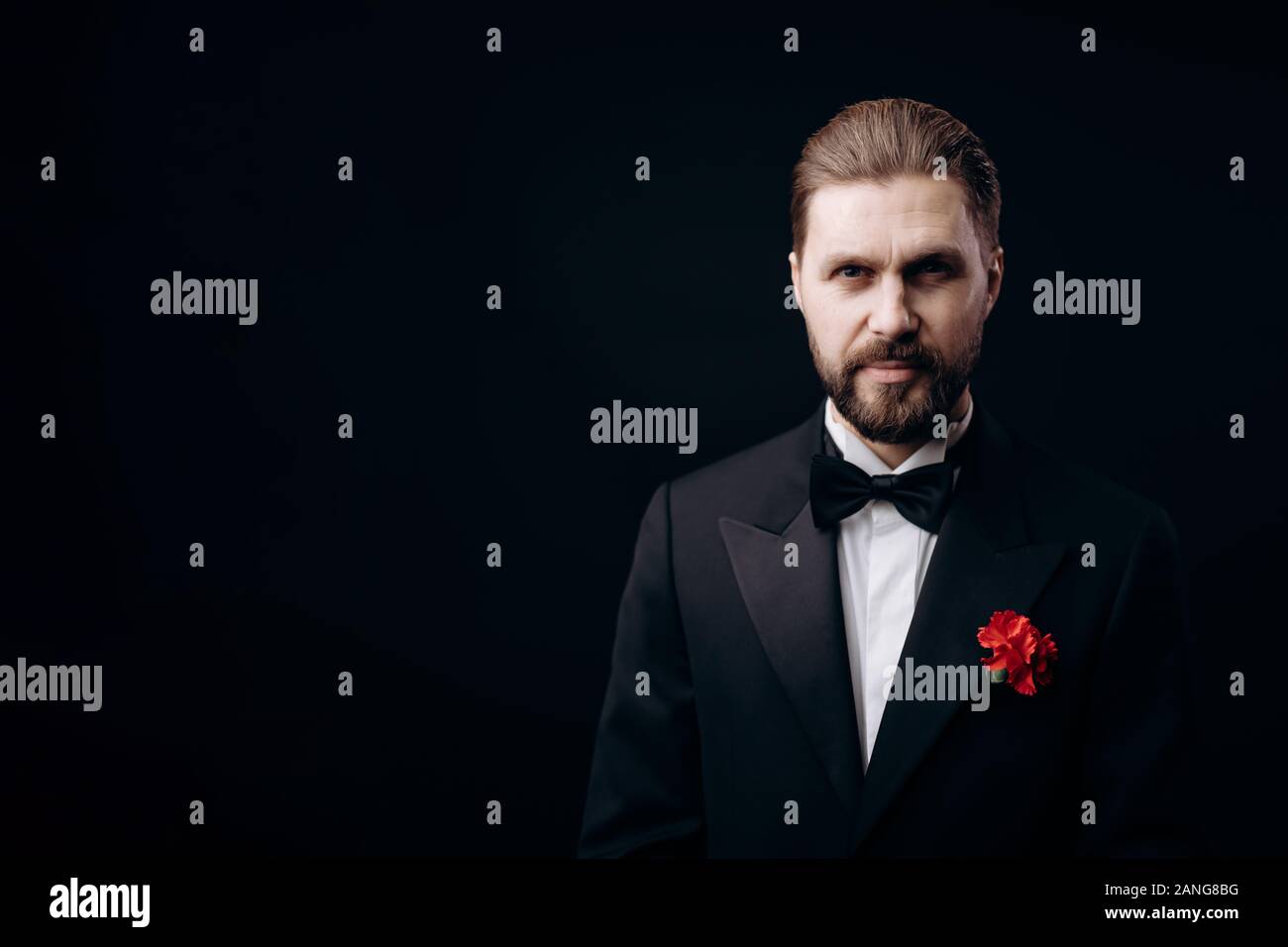 Handsome Brunet in Black Tie With a Carnation Boutonniere Stock Photo