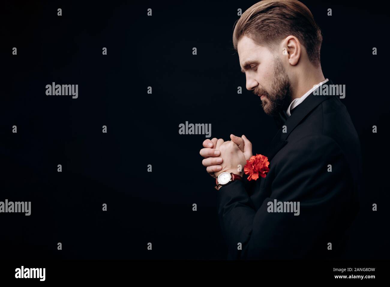 Bearded Man in Dinner Suit Rubbing His Hands in Pray Stock Photo