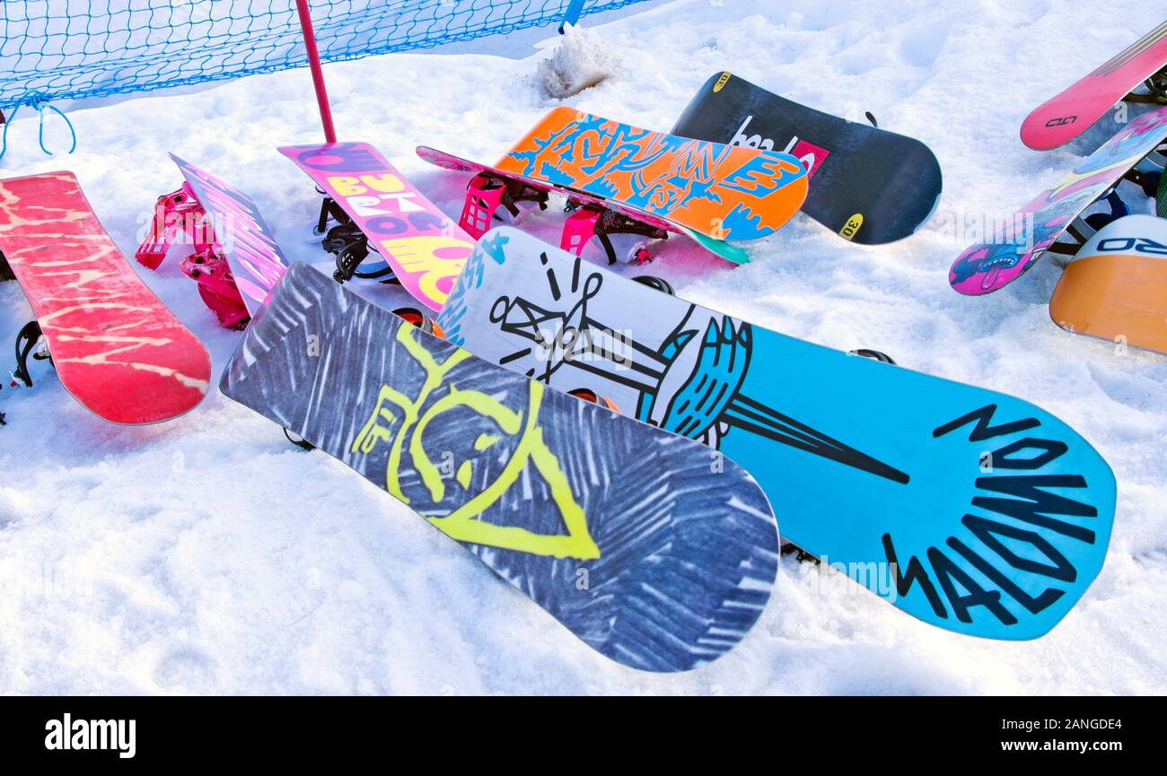 Colourful snowboards stacked on snow at Cairngorm Mountain Ski Centre, Cairngorms National Park, Scottish Highlands, near Aviemore, Scotland UK Stock Photo