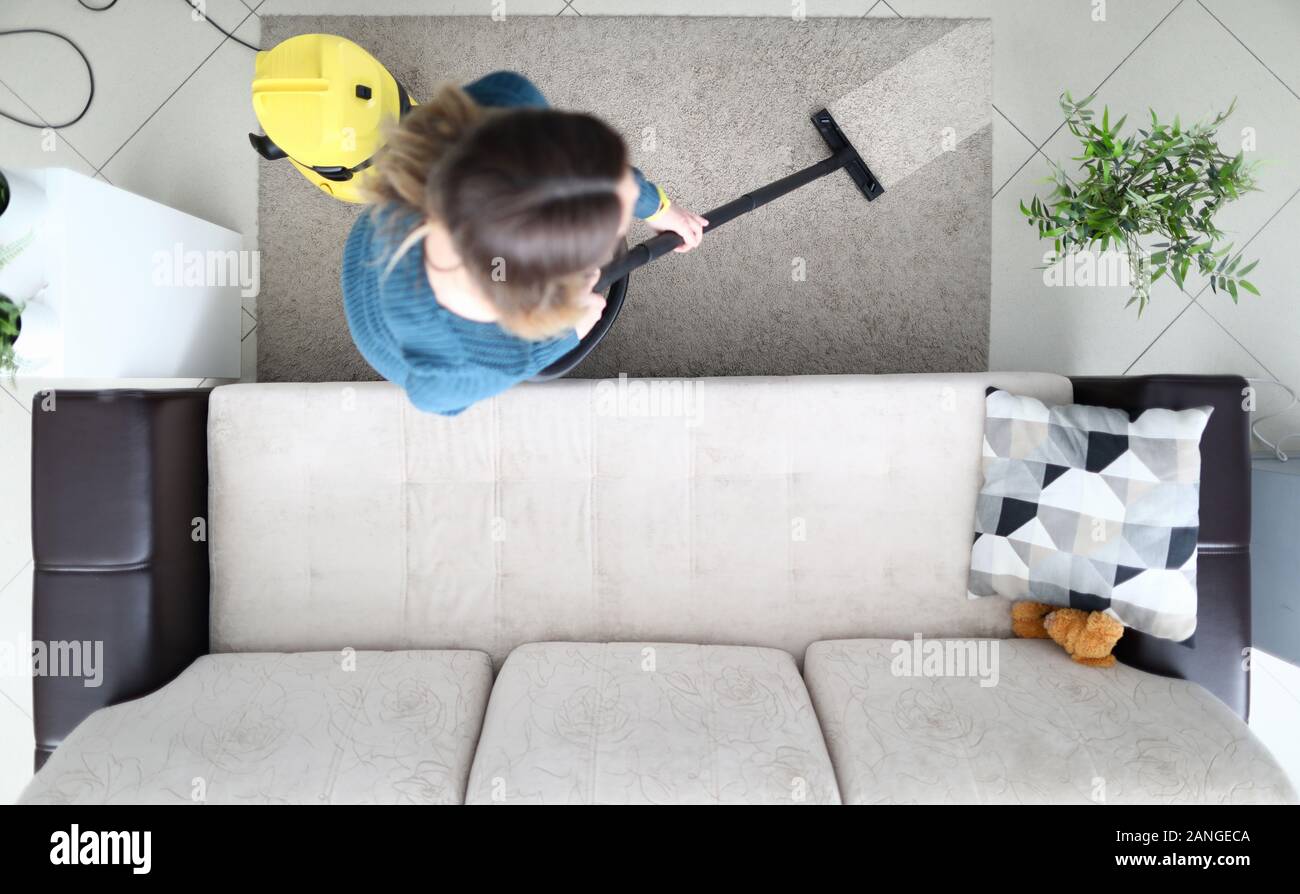 Woman cleaning carpet with vacuum cleaner at home Stock Photo - Alamy