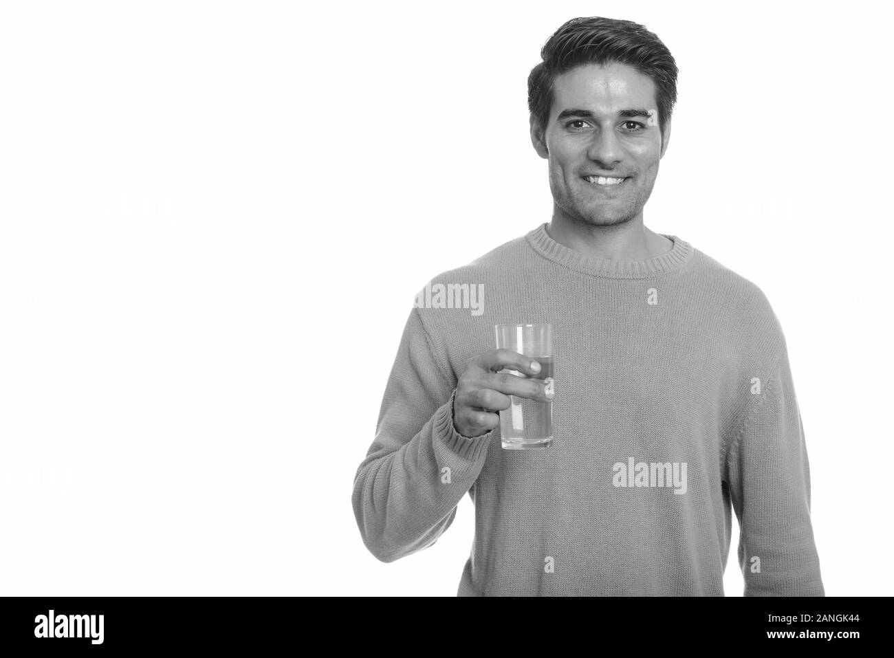Young happy Persian man holding glass of water Stock Photo - Alamy