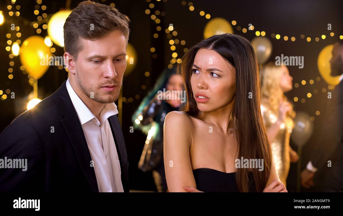 Angry woman feeling offence, suspecting boyfriend in cheating and betrayal Stock Photo