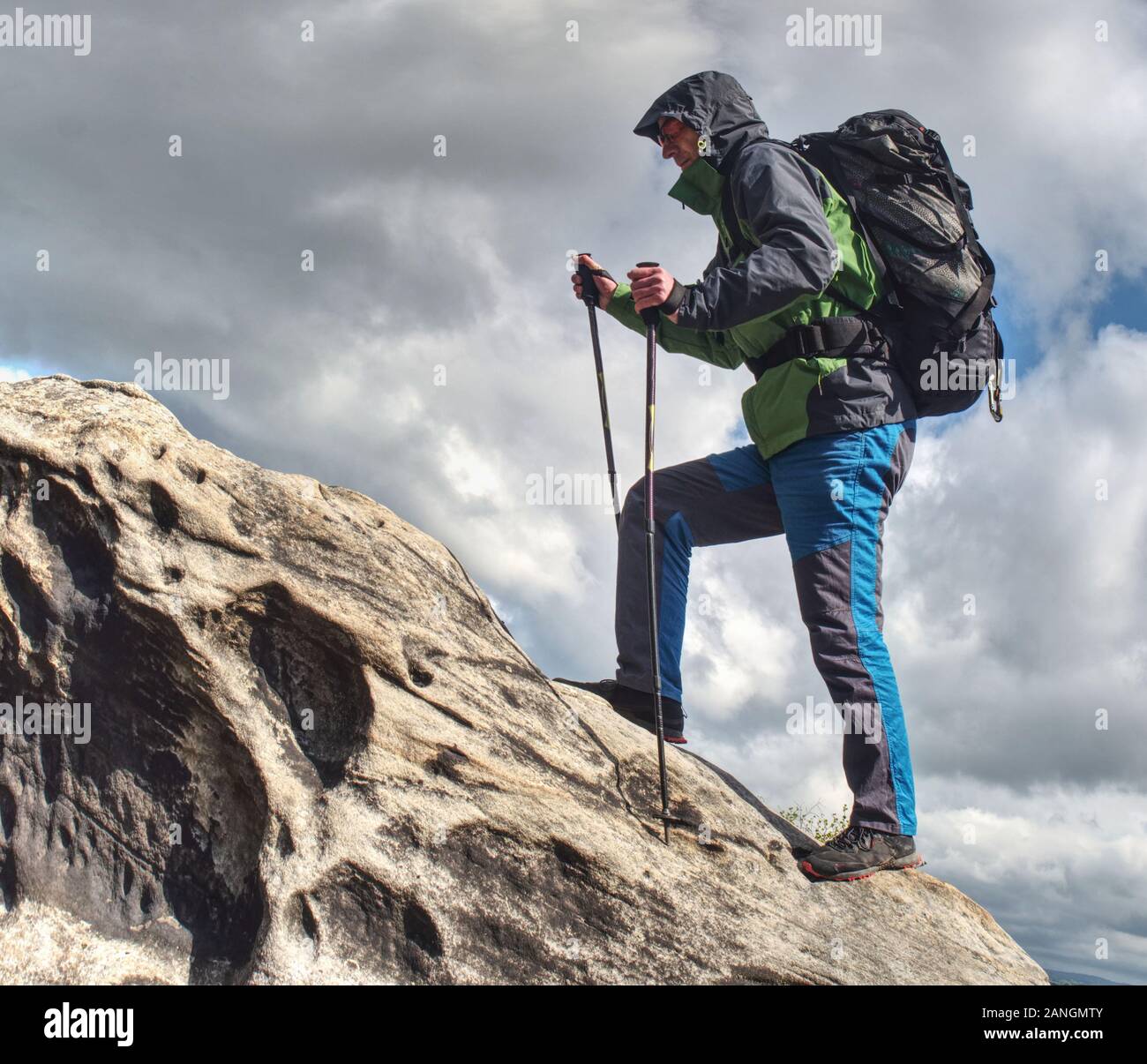 Climbing high up. Mountaineer with backpack hiking in mountains