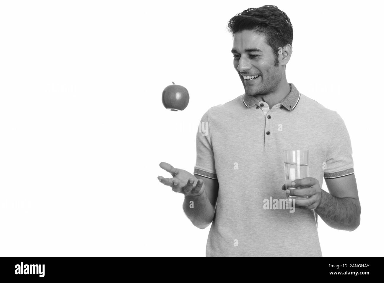 Young happy Persian man holding red apple and glass of water Stock ...