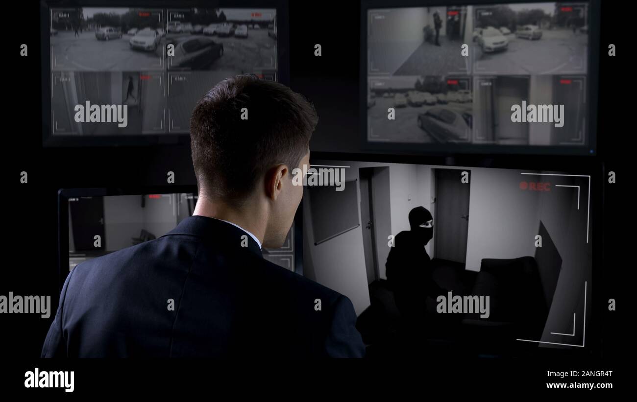 Security guard in front CCTV footage watching bank robbery, safety and guarding Stock Photo