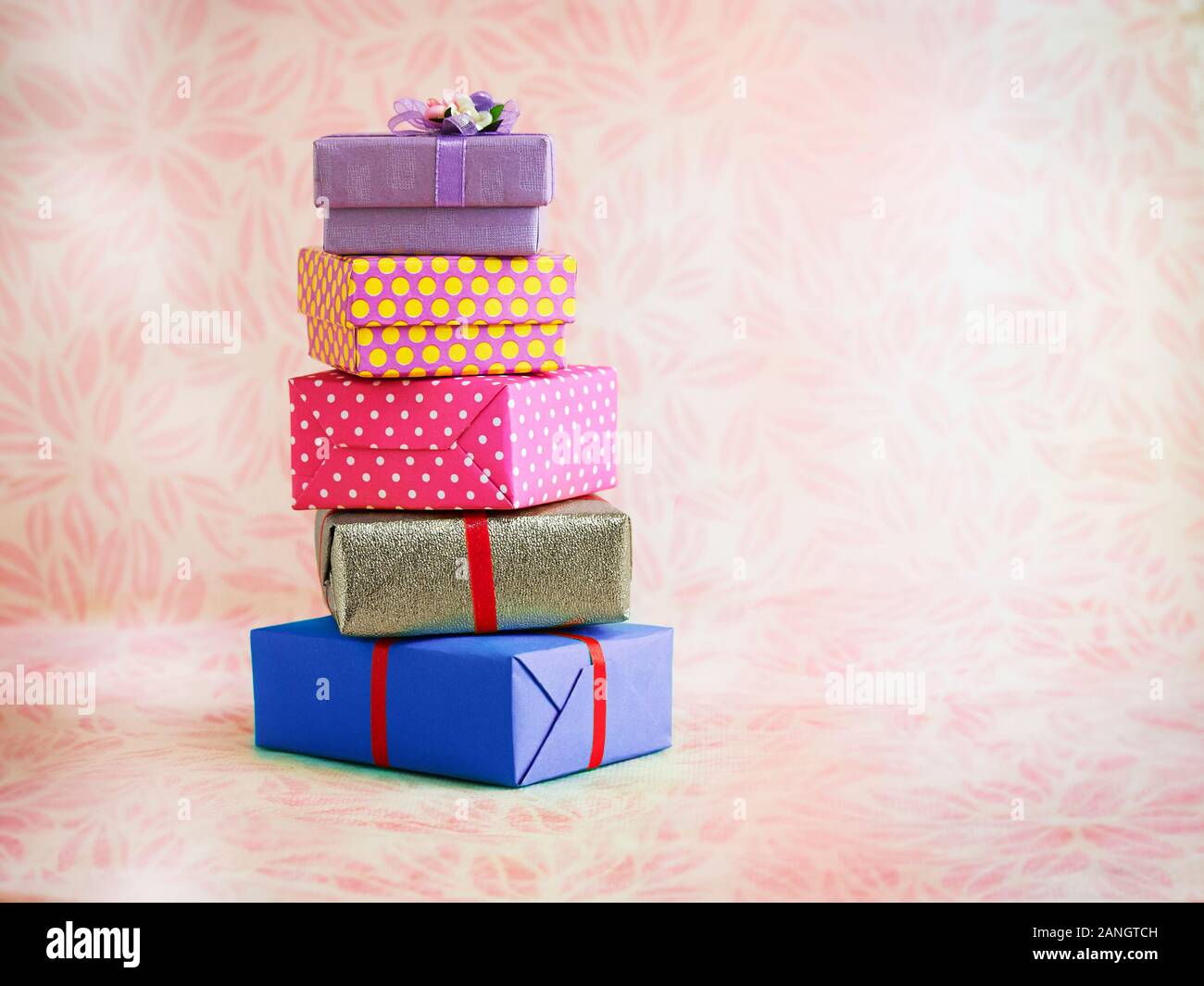 five colourful square gift boxes with soft pink background Stock Photo