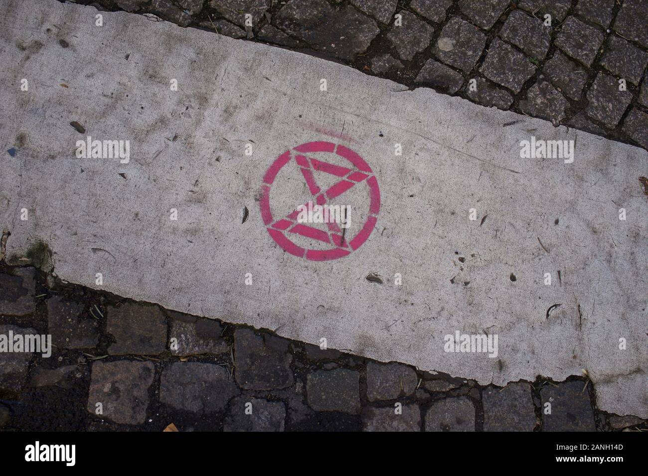 Extinction Rebellion Logo, graffitti stencilled on road, Paris, January 2020 Stock Photo