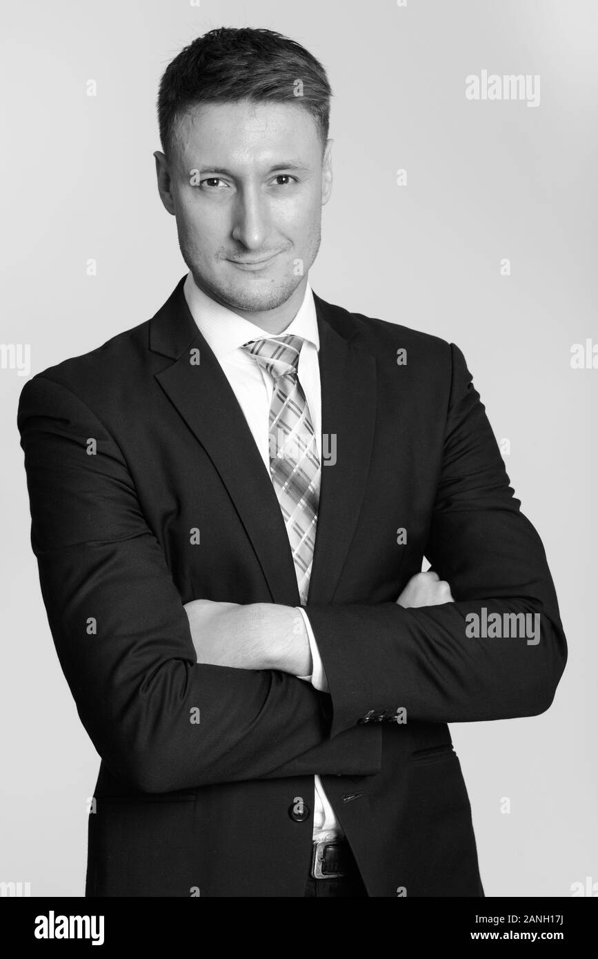 Portrait of young handsome businessman in suit with arms crossed Stock ...