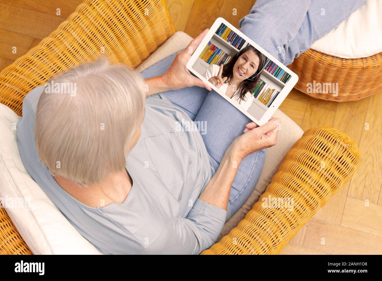 E-learning concept: senior woman with tablet computer watching an online english lesson. Stock Photo