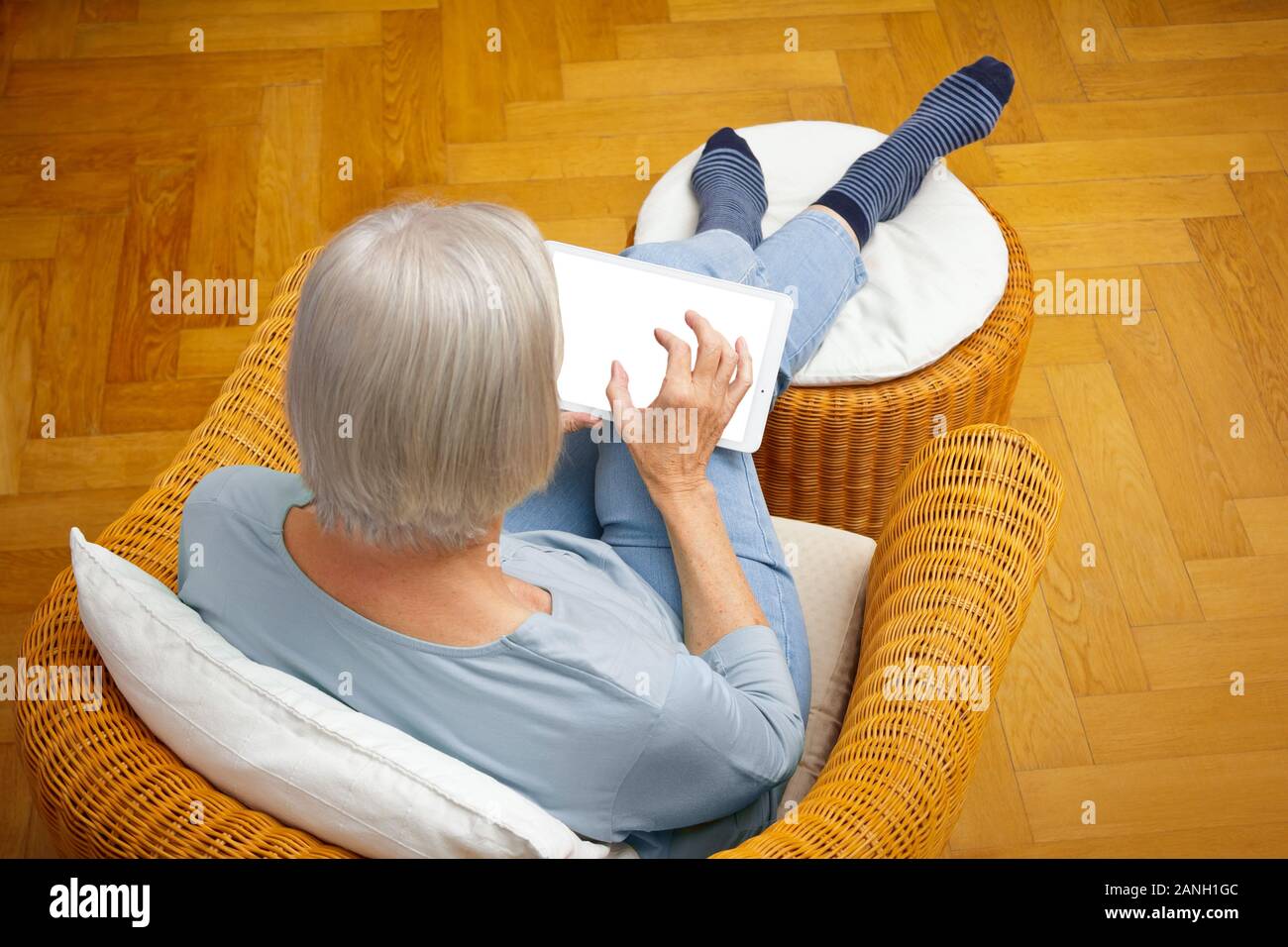 Technology and senior people template: elderly woman with tablet computer enlarging something on the screen. Stock Photo