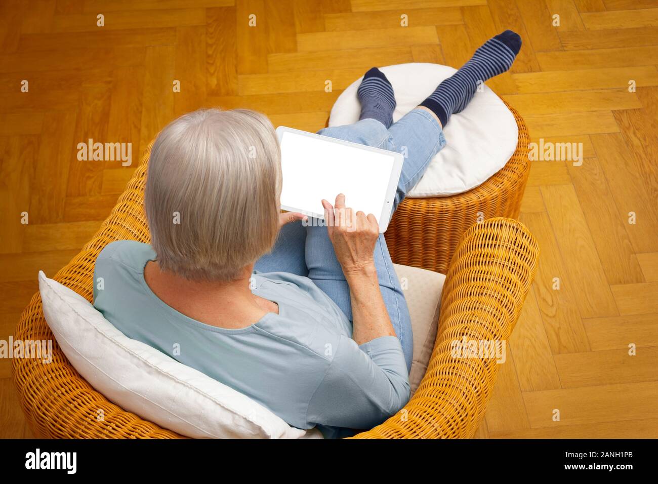 Technology and senior people template: elderly woman with tablet computer at home, touching blank screen. Stock Photo