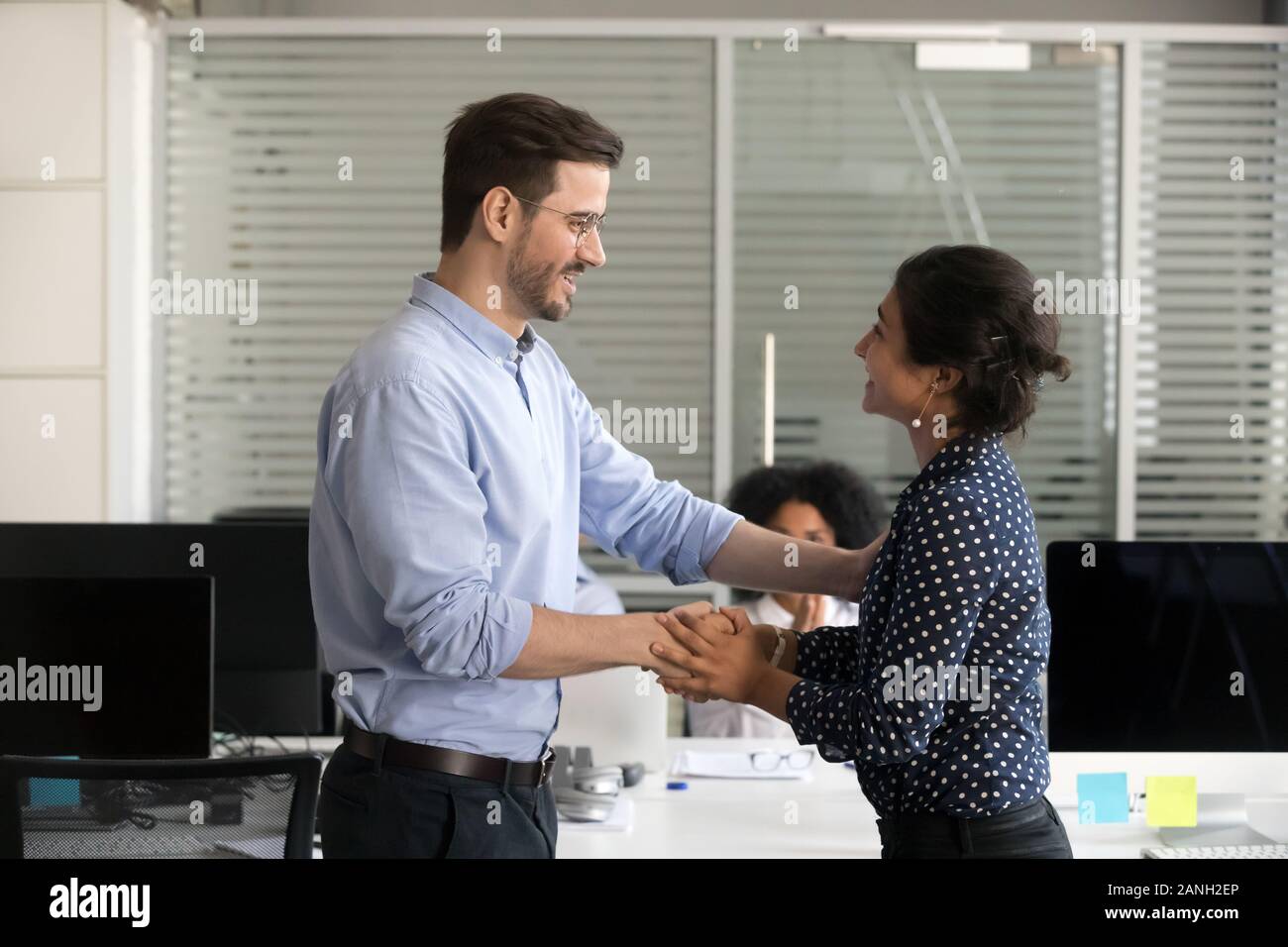 Male boss shake hand of excited millennial female intern or trainee greeting with successful training and employment, CEO or employer handshake woman Stock Photo