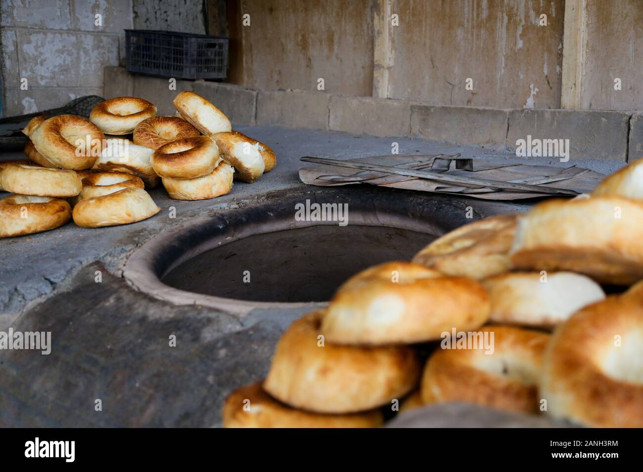 Taditional Kyrgiz local bakery oven with fresh bread of tandyr nan aside. Stock Photo