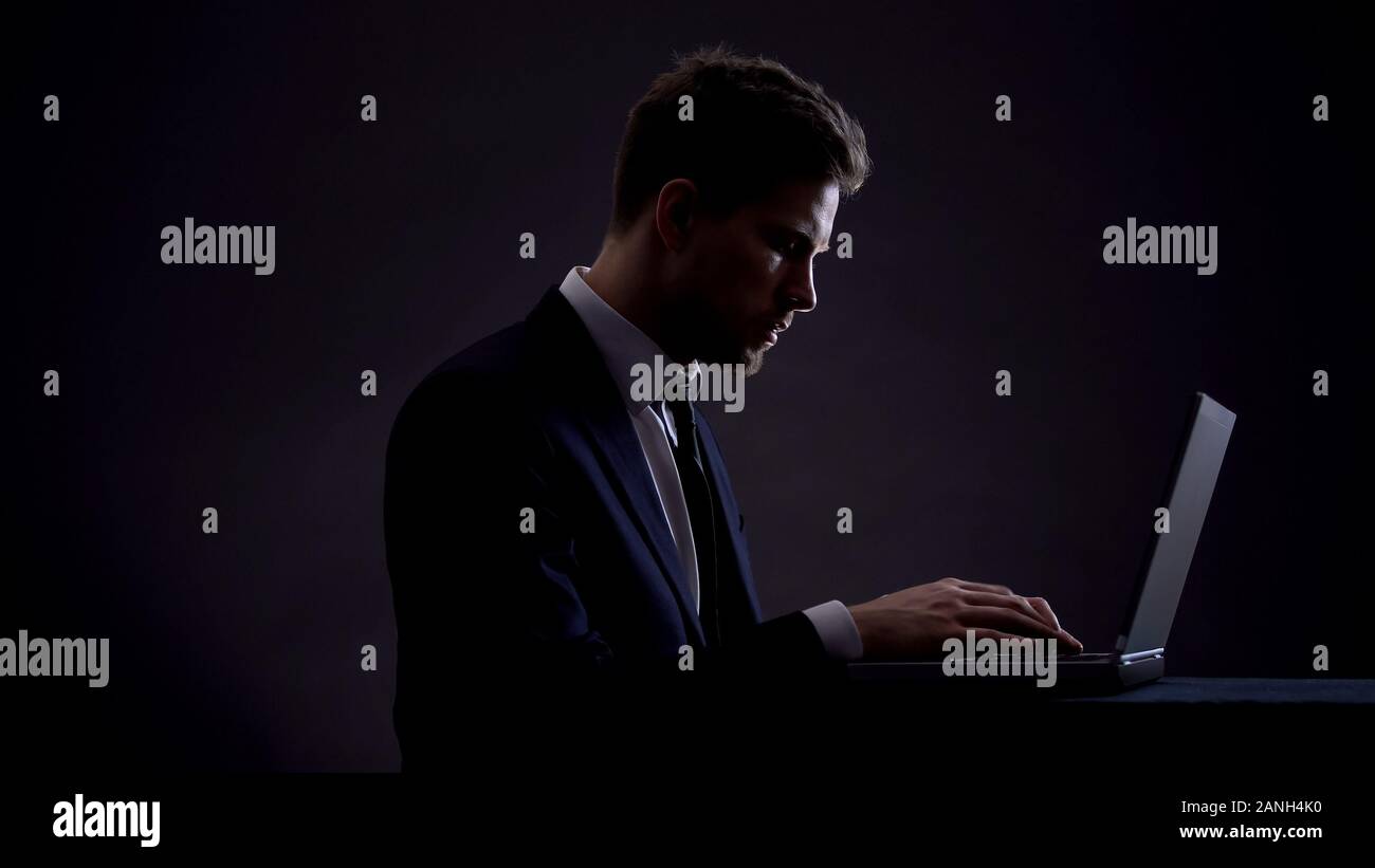 Businessman working on laptop at night shift, overworking concept, workaholic Stock Photo