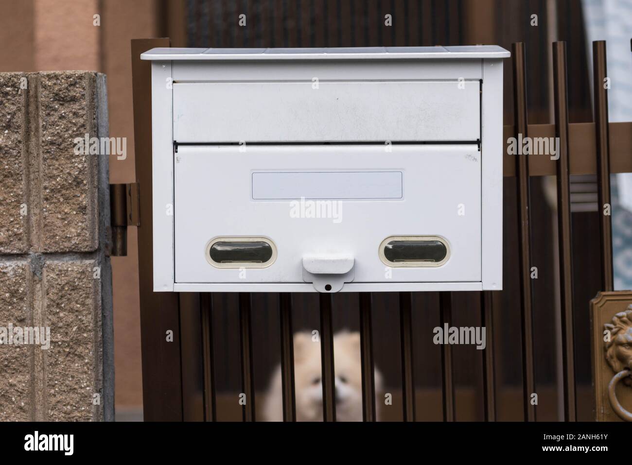 White mailbox or post box at a gate of a residential house. Stock Photo