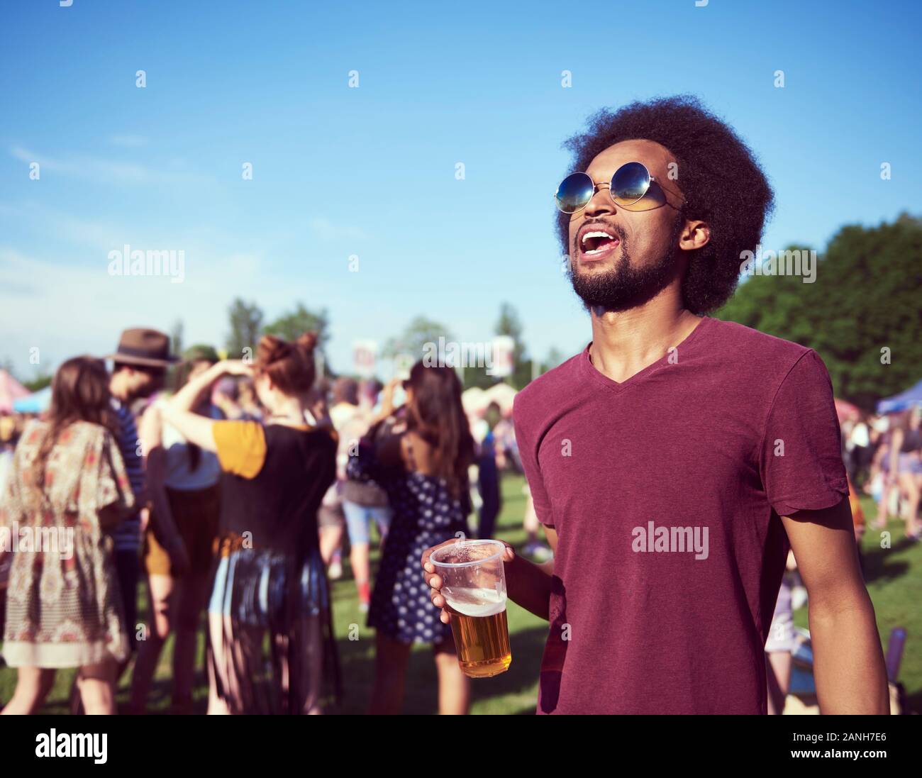 Young African man drinking beer at the festival Stock Photo