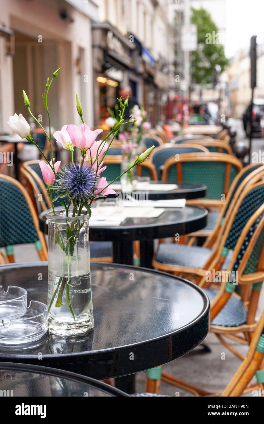 Flowers on the tables of a Parisian cafe in Paris, France on the Rue de Buci. Stock Photo