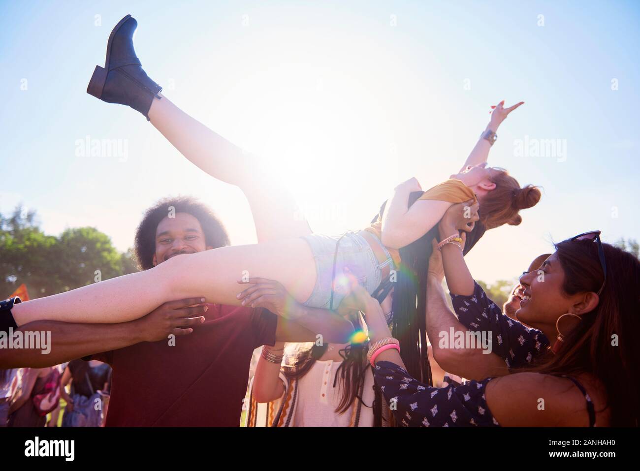 Excited woman crowd surfing at music festival Stock Photo