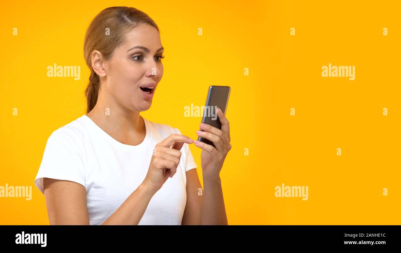 Surprised woman using smartphone application, online shopping discount, gadget Stock Photo