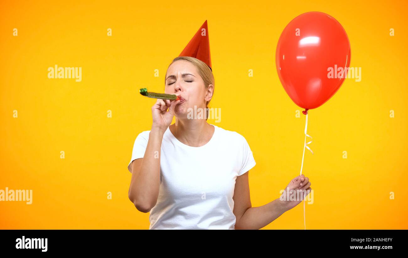 Young woman blowing party horn hi-res stock photography and images - Alamy