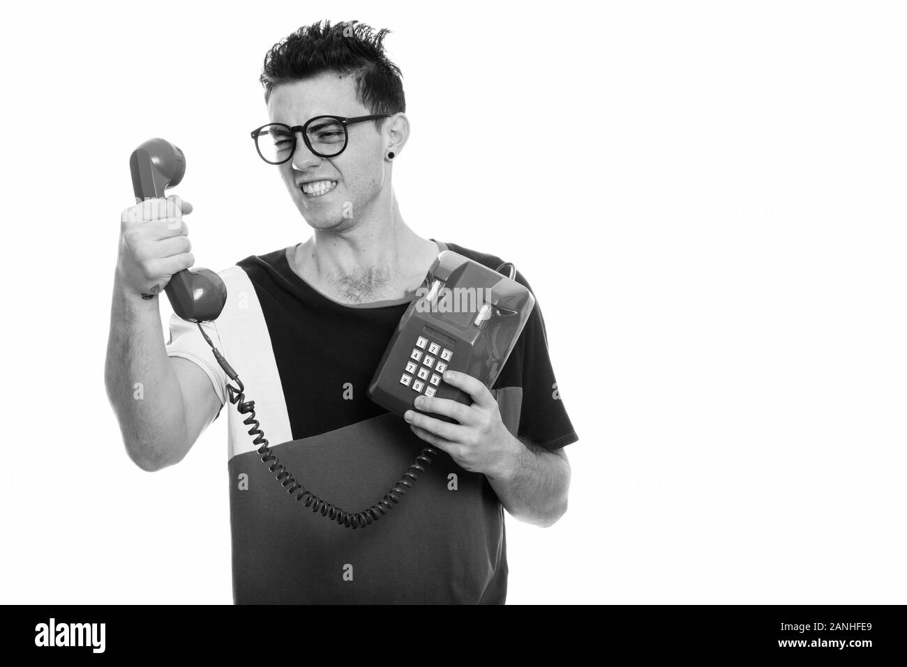 Angry young man holding old telephone in black and white Stock Photo