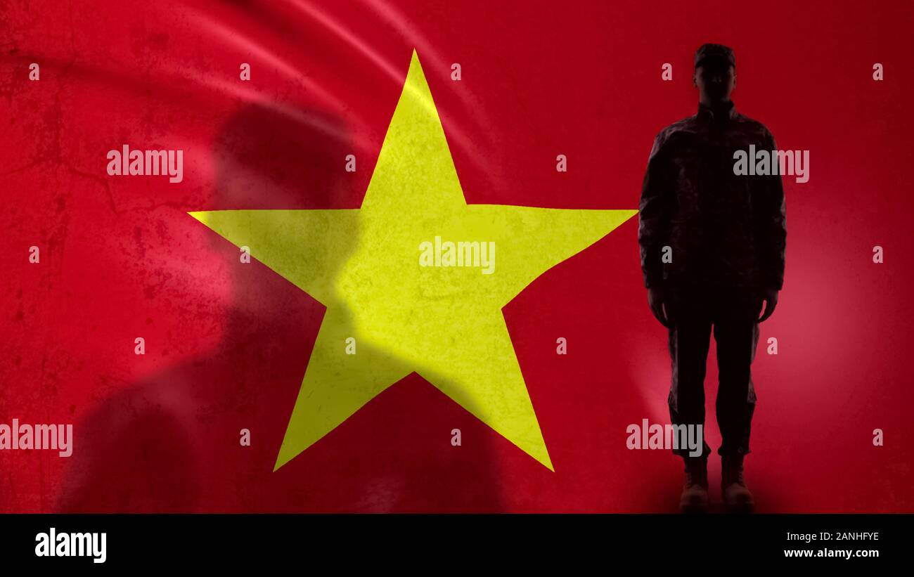Vietnamese soldier silhouette standing against national flag, proud sergeant Stock Photo