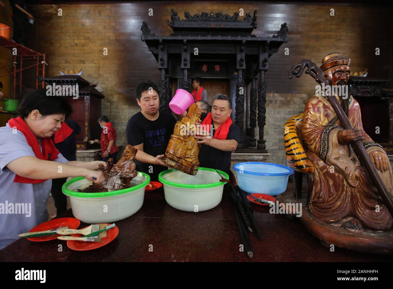 People clean statues during the celebration at the Amurva Bhumi temple