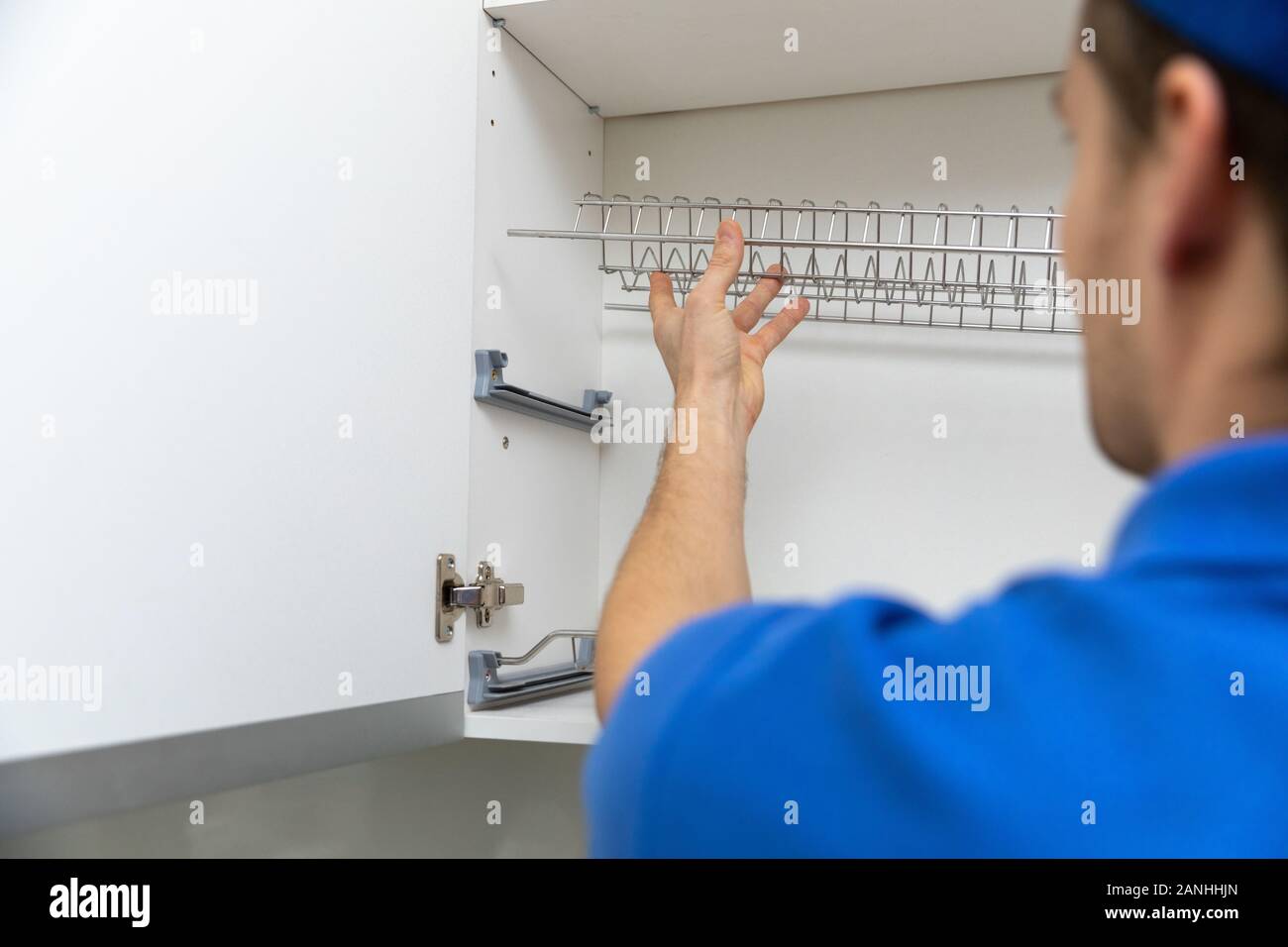 furniture service worker installing kitchen cabinet dish rack Stock Photo