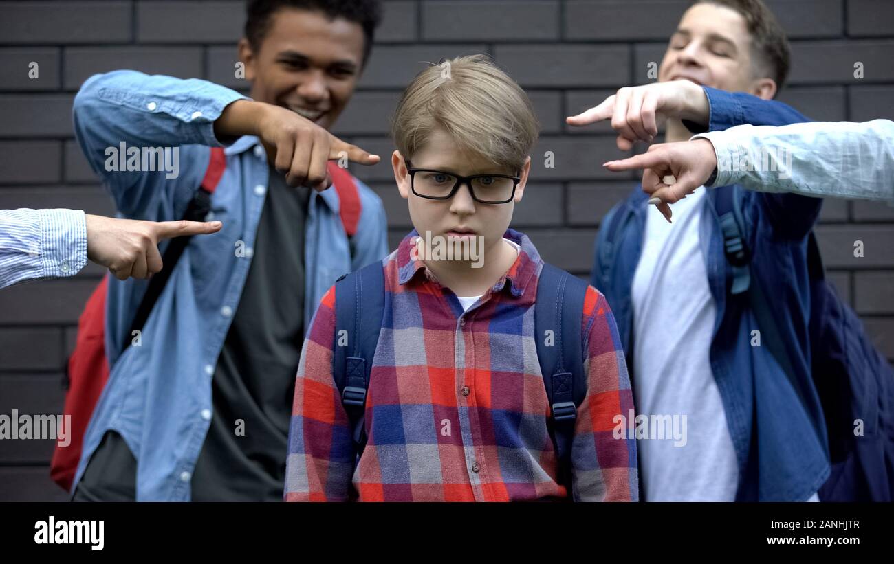 Bullied boy feeling ashamed, depressed by classmates mockery, verbal abuse Stock Photo