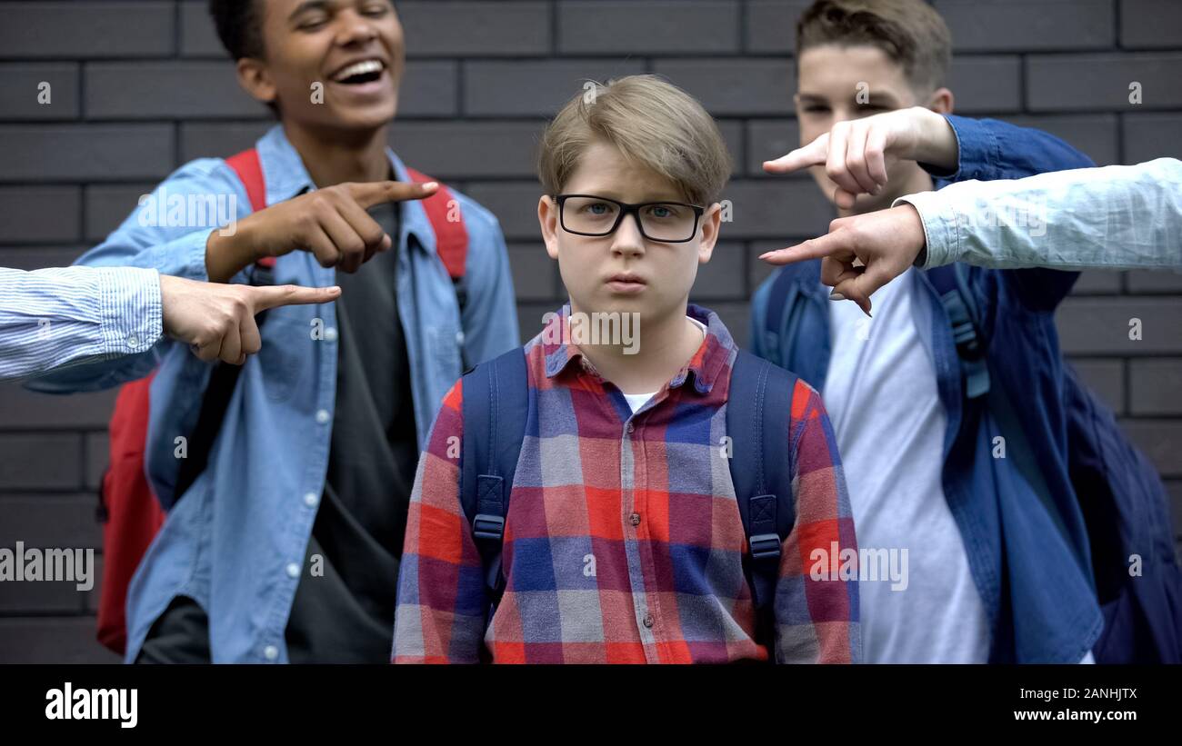 Bullied boy looking at camera, depressed by classmates mockery, verbal abuse Stock Photo