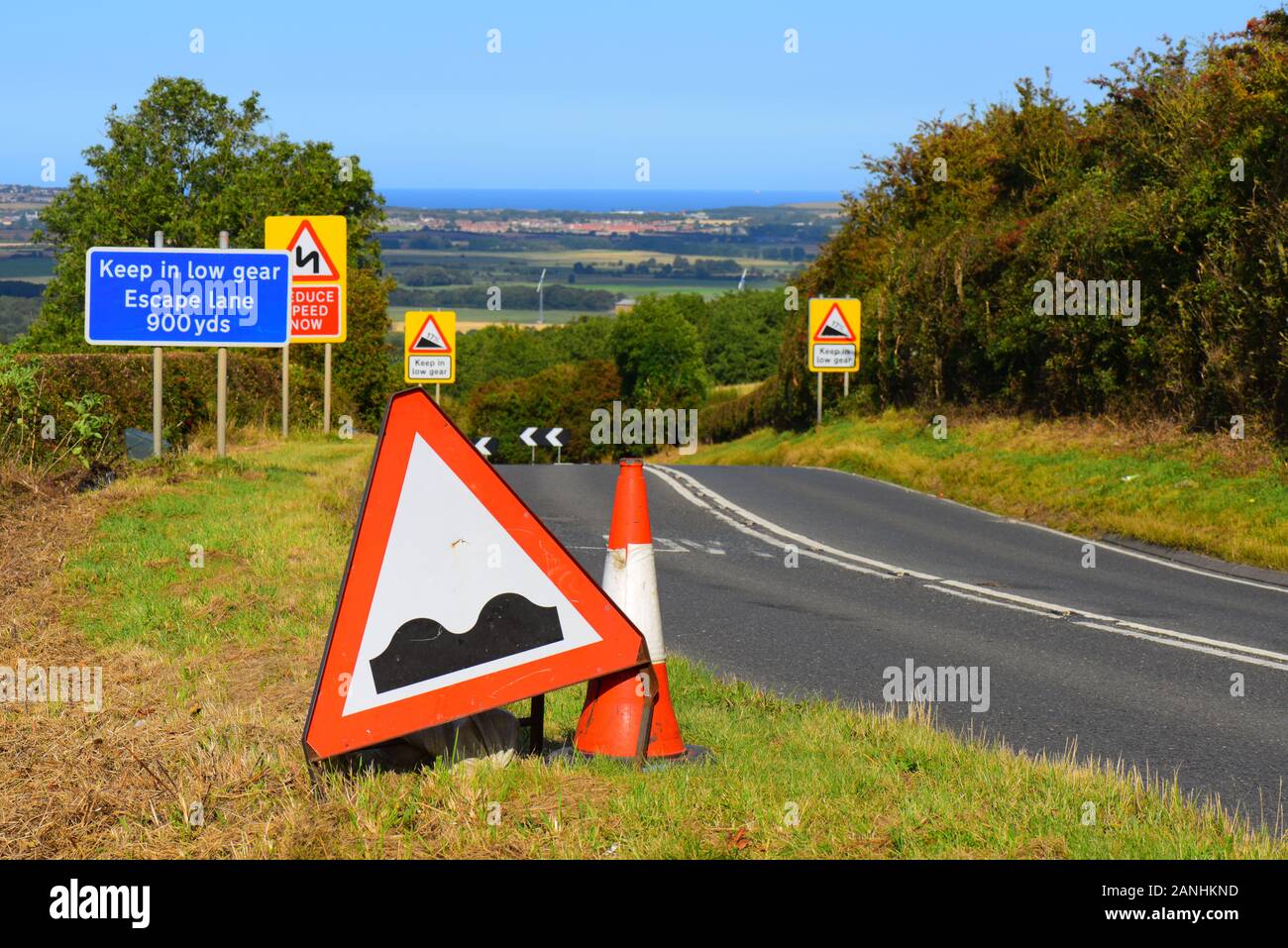 warning sign of uneven road potholes ahead of steep hill at staxton yorkshire united kingdom Stock Photo