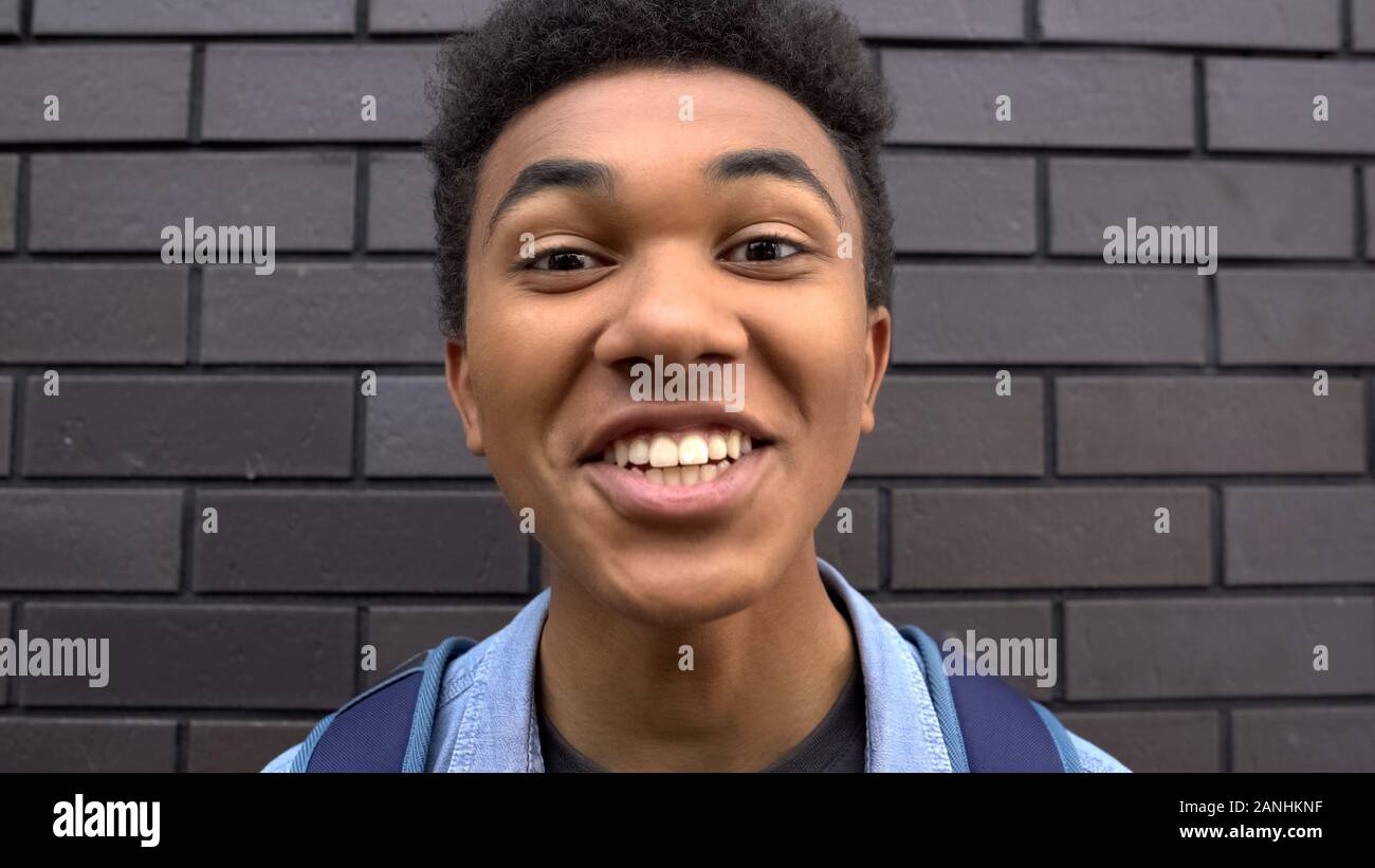 Impudent afro-american boy teasing, laughing into camera, victim of bullying POV Stock Photo