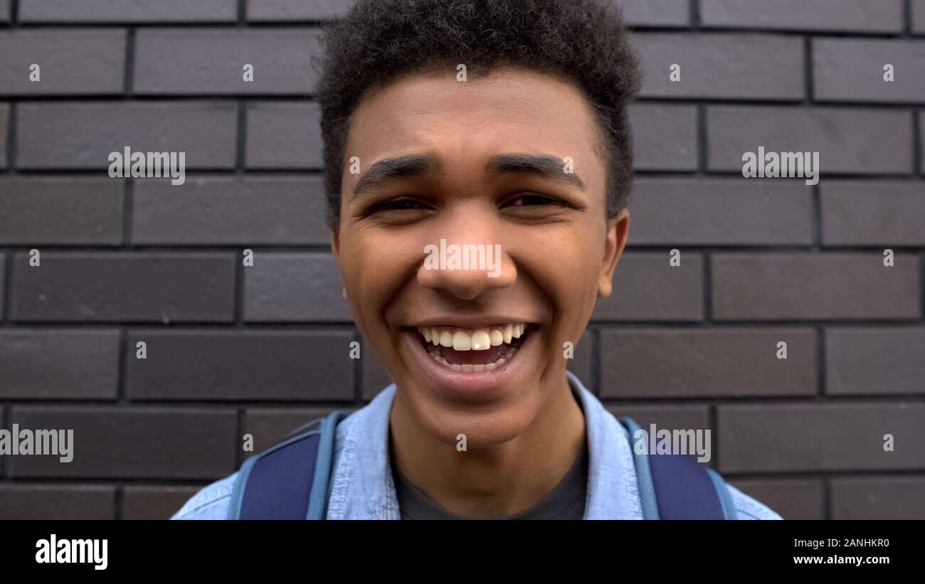 Aggressive afro-american boy teasing laughing on camera, victim of bullying POV Stock Photo