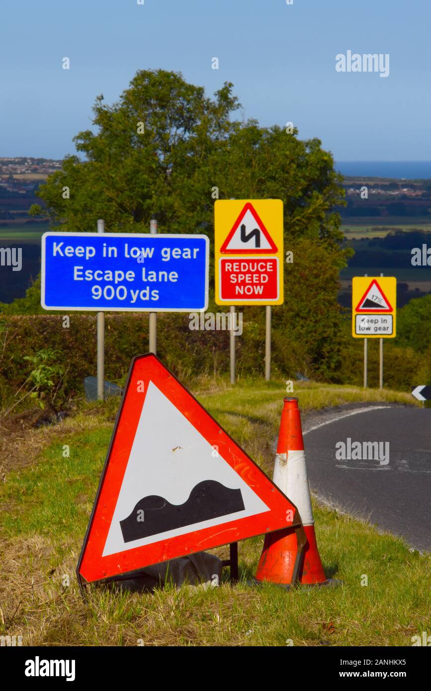 warning sign of uneven road potholes ahead of steep hill at staxton yorkshire united kingdom Stock Photo