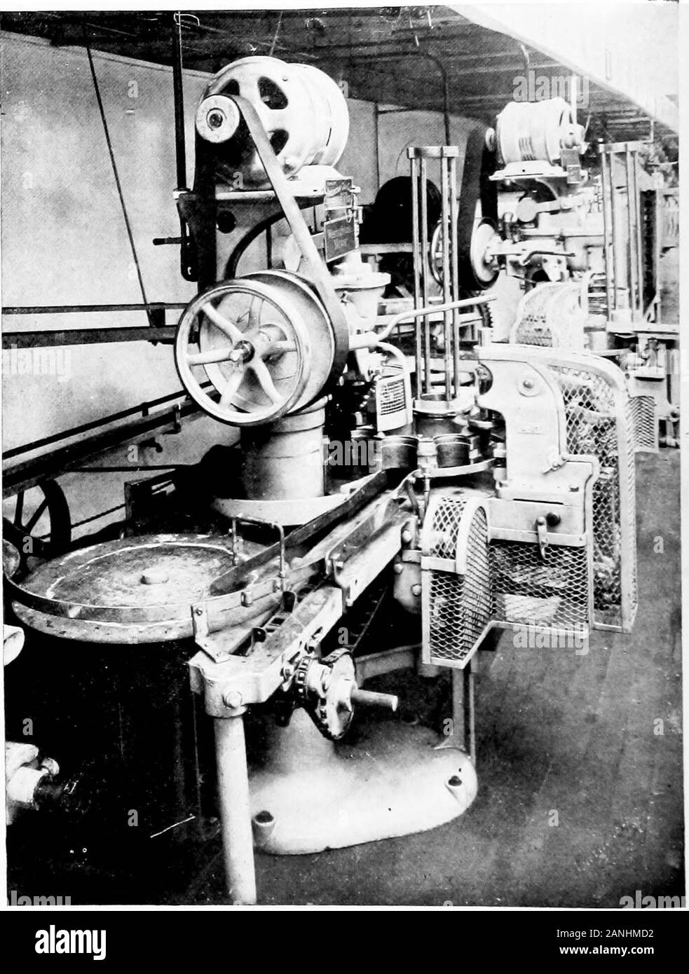 Canned foodsModern processes of canning in the United States, general system of grading, and description of products available for export .. . Filling machine. This operation is known as exhausting, and is for the purpose of producinga can with ends properly collapsed. CLOSING. The method of closing the cans depends upon the type used. Thesolder-top cans are sealed by automatic machines, which wipe the tops,place the caps, apply the flux, heat the solder, and close the vent withoutthe introduction of hand labor. The hand soldering copper or cappingsteel is to be found in only the smallest plan Stock Photo