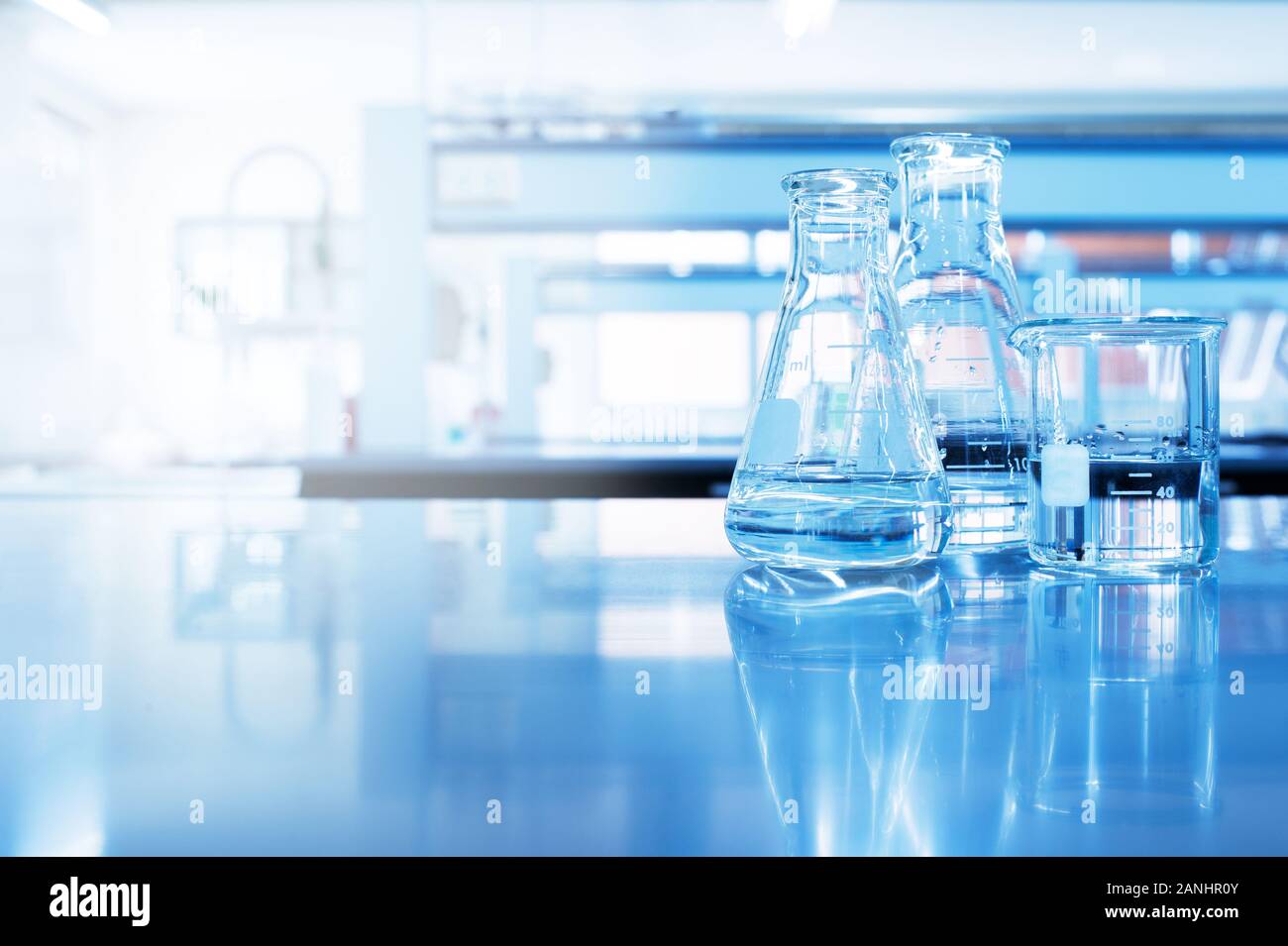 clear water in beaker and flask glass in chemistry blue science