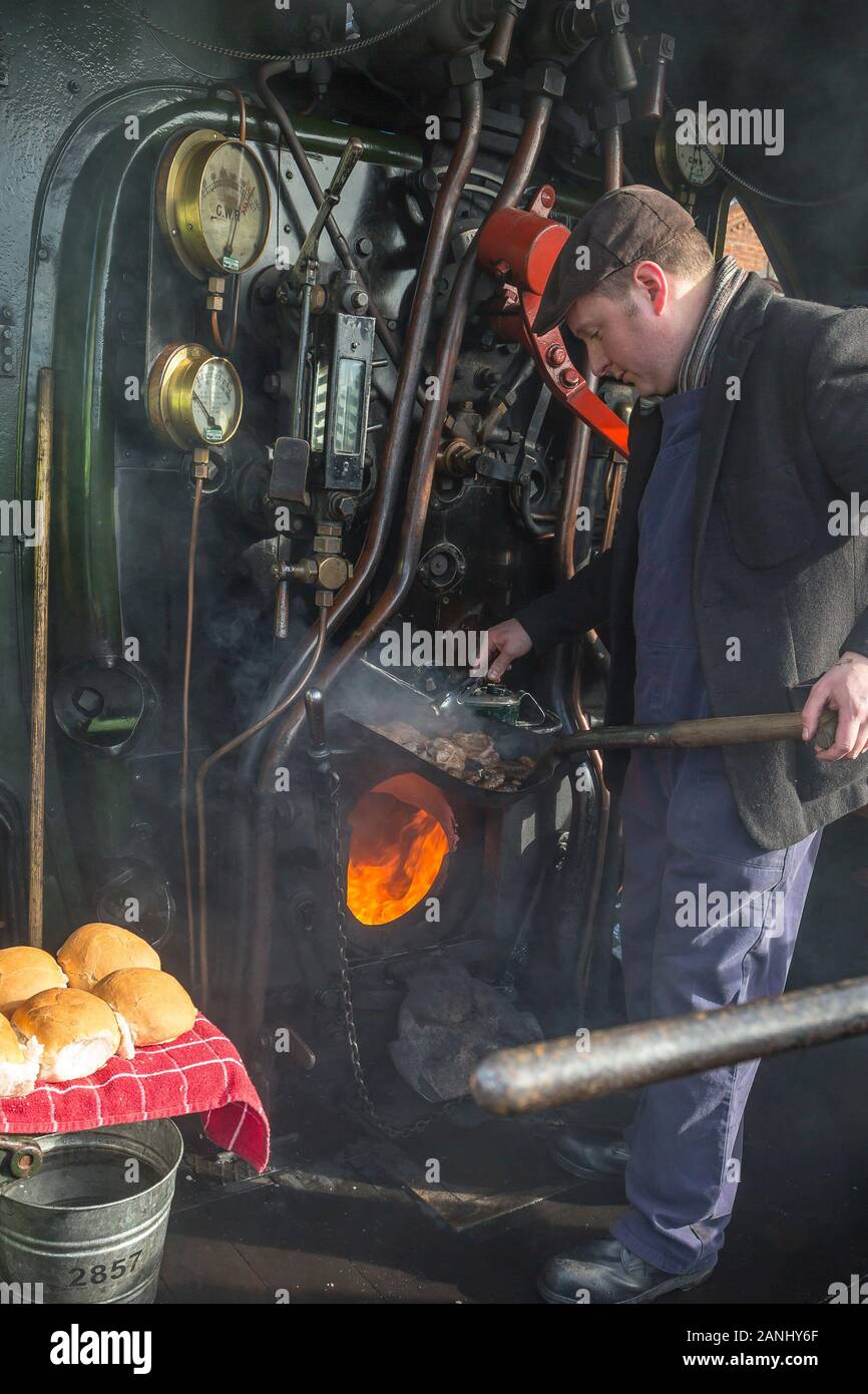 On board steam locomotive cab, driver cooking breakfast for the crew. Stock Photo