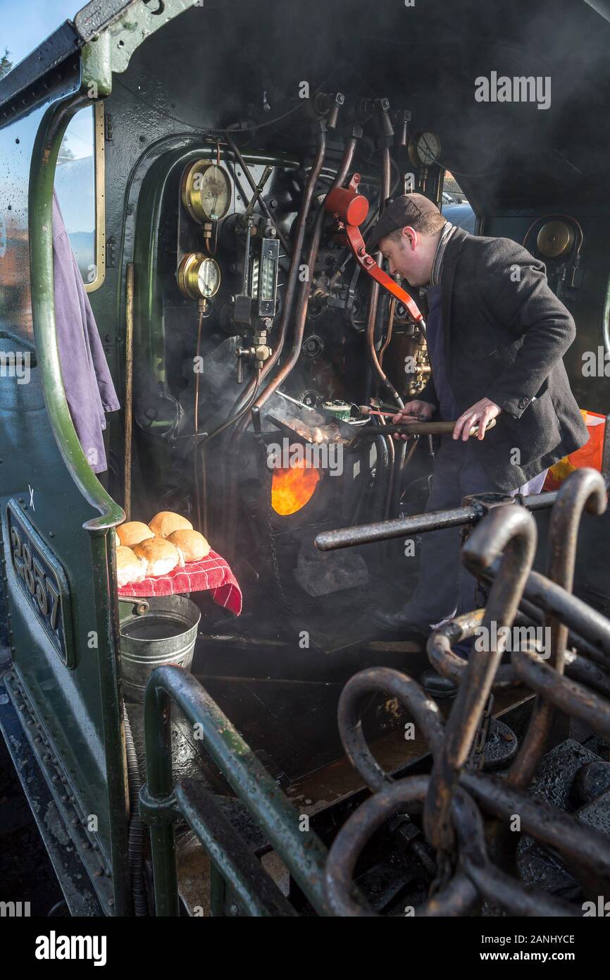 On board steam locomotive cab, driver cooking breakfast for the crew. Stock Photo