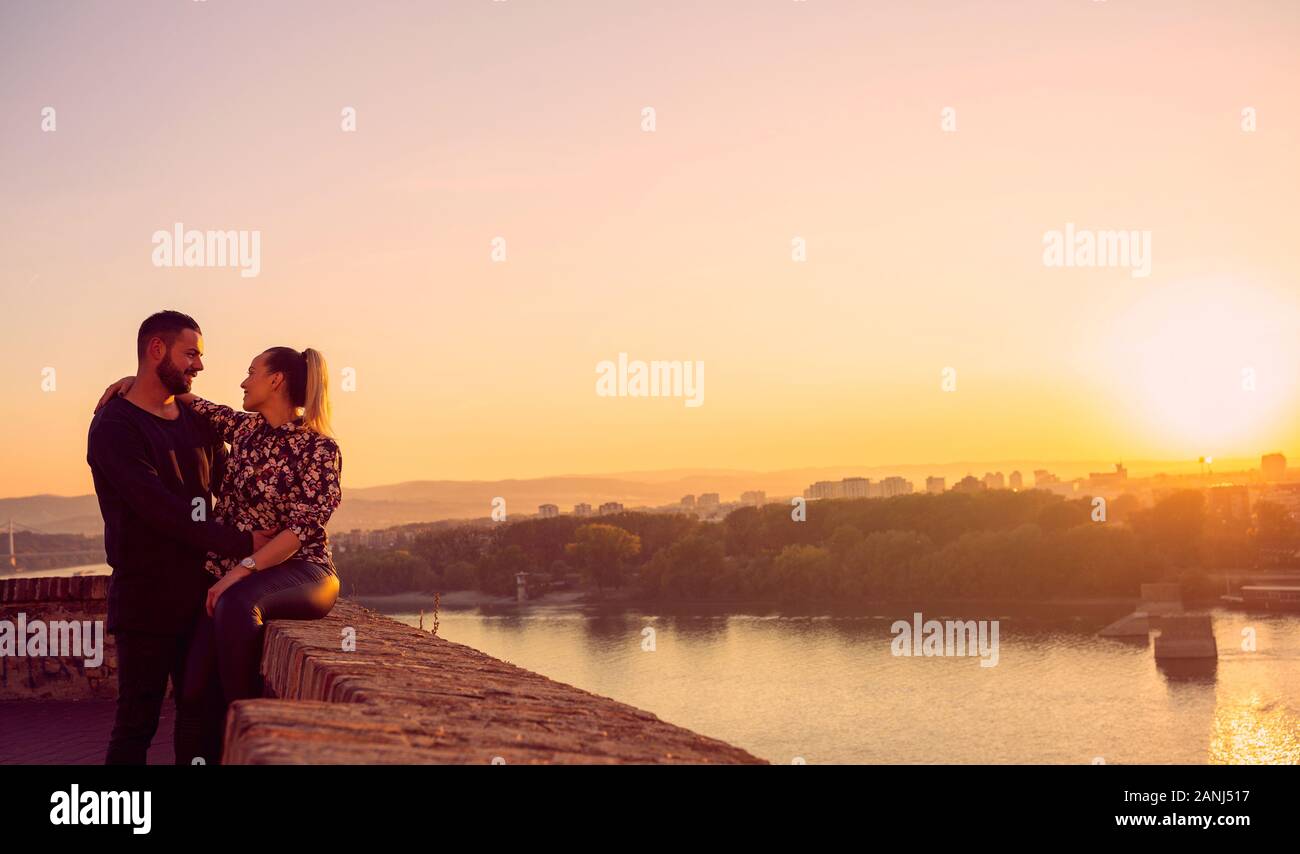 young romantic man and woman spend time together at sunset Stock Photo