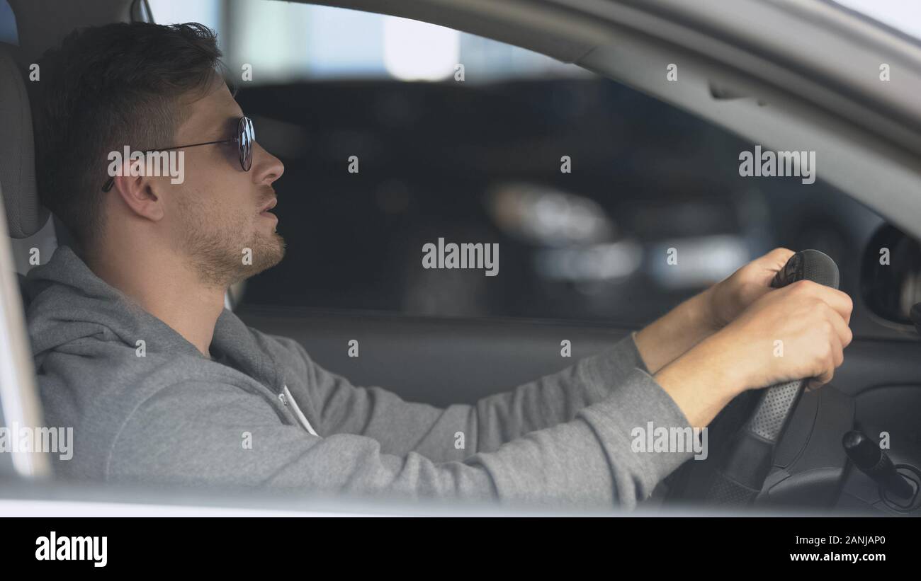 Male driver wearing polarized sunglasses, protecting eyes for safe