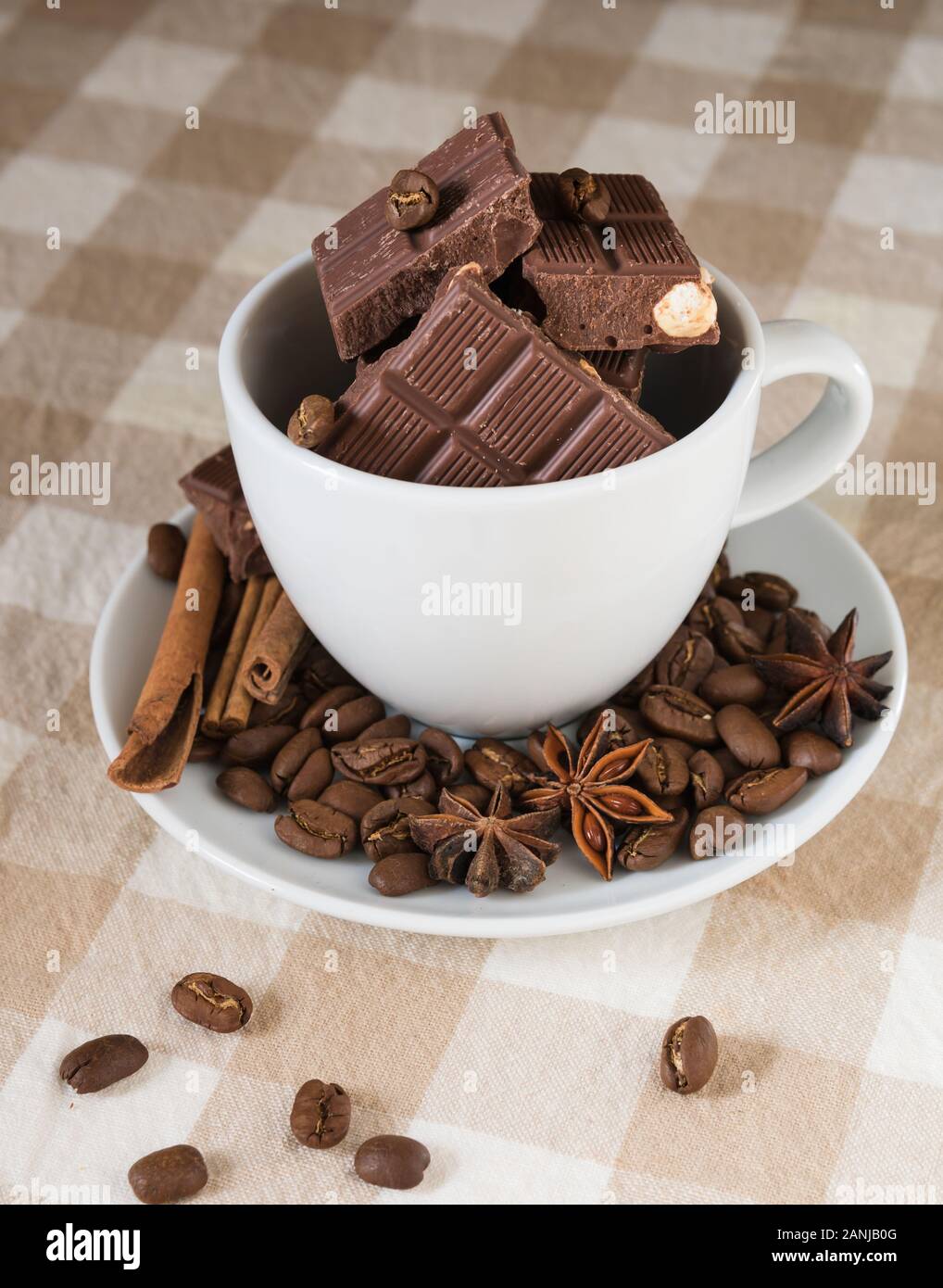 still life, installation, a cup with chocolate, coffee beans, anise and cinnamon sticks on a table Stock Photo