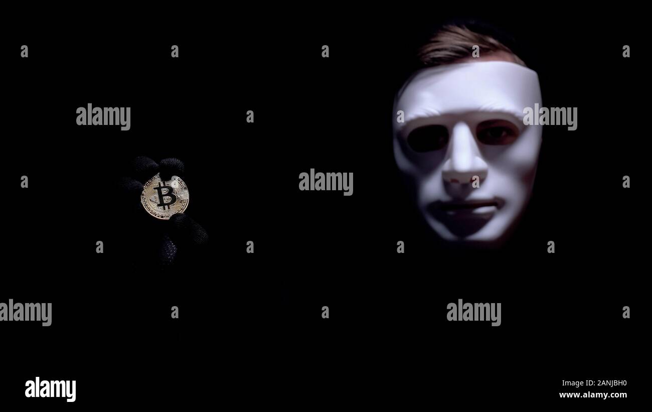 Man showing bitcoin, fearful anonymous mask on face, cyber attack, robbery  Stock Photo - Alamy