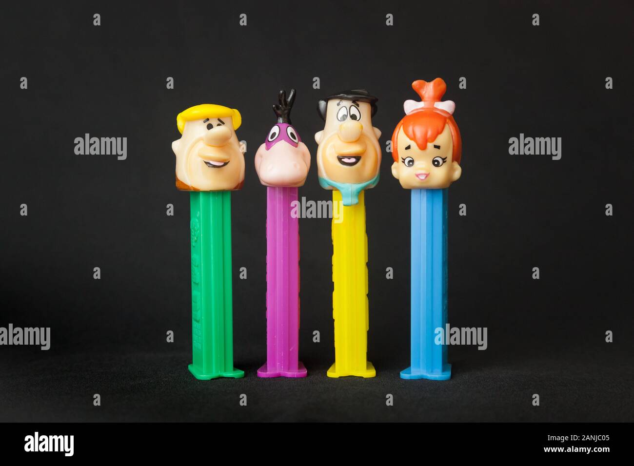 WOODBRIDGE, NEW JERSEY / UNITED STATES - January 16, 2020: Four Flintstones Pez dispensers are lined up on a black background Stock Photo