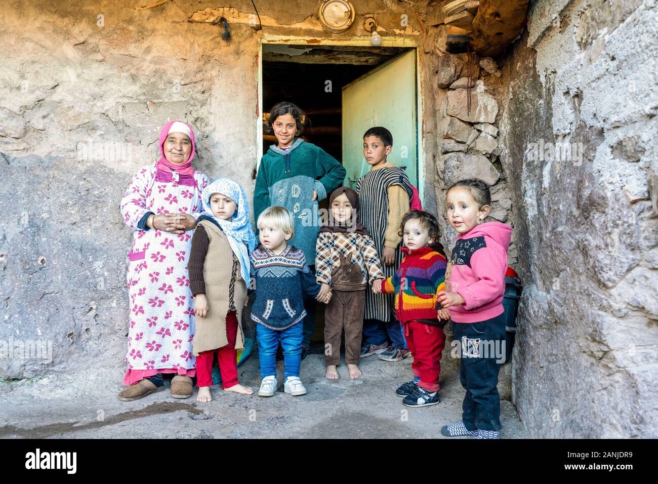 Aroumd, Morocco - January 7, 2020: Berber grandmother taking care of many kids in front of her house Stock Photo