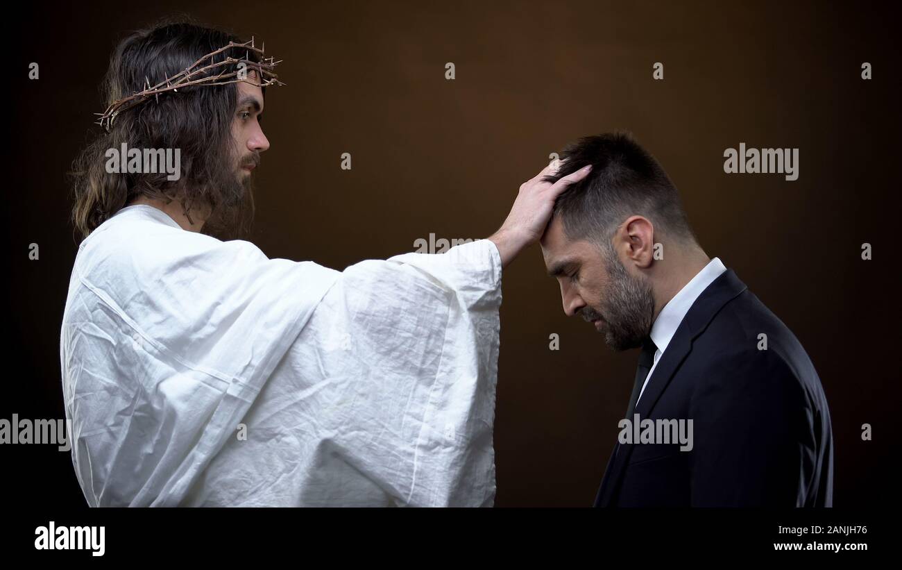 Savior putting hand on male head, spiritual guide, religious love, helping God Stock Photo