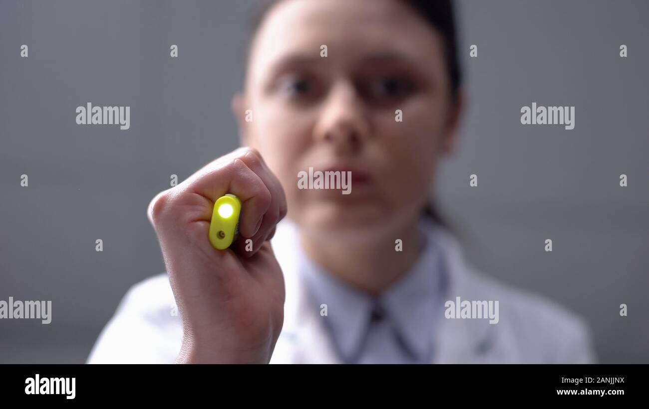 Doctor checking eyes reaction for light, emergency paramedic helping patient Stock Photo