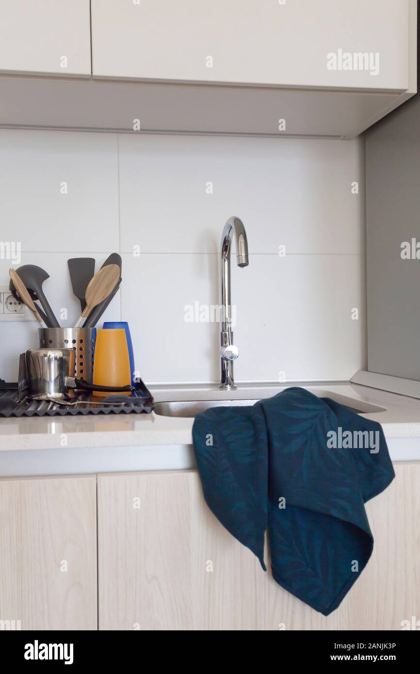 The interior of the clean modern kitchen with sink, utensil drying and cotton dishcloth Stock Photo