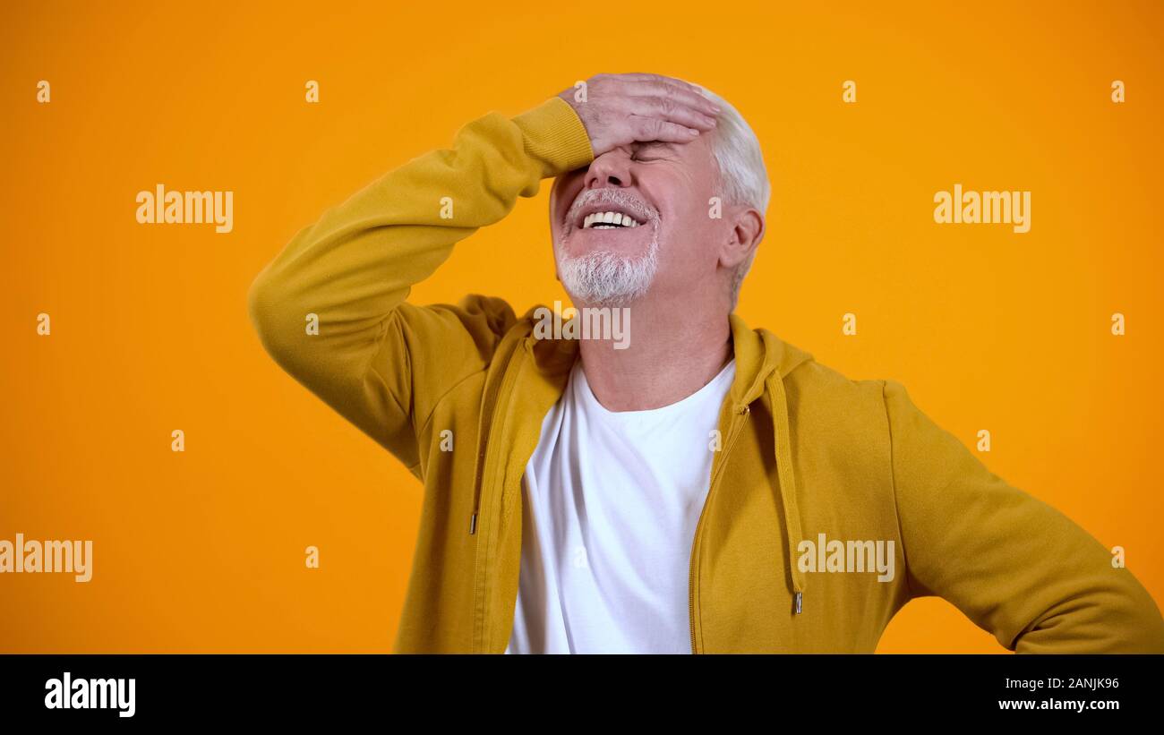 Upset aged man demonstrating face-palm gesture, failure sign, elderly loser Stock Photo