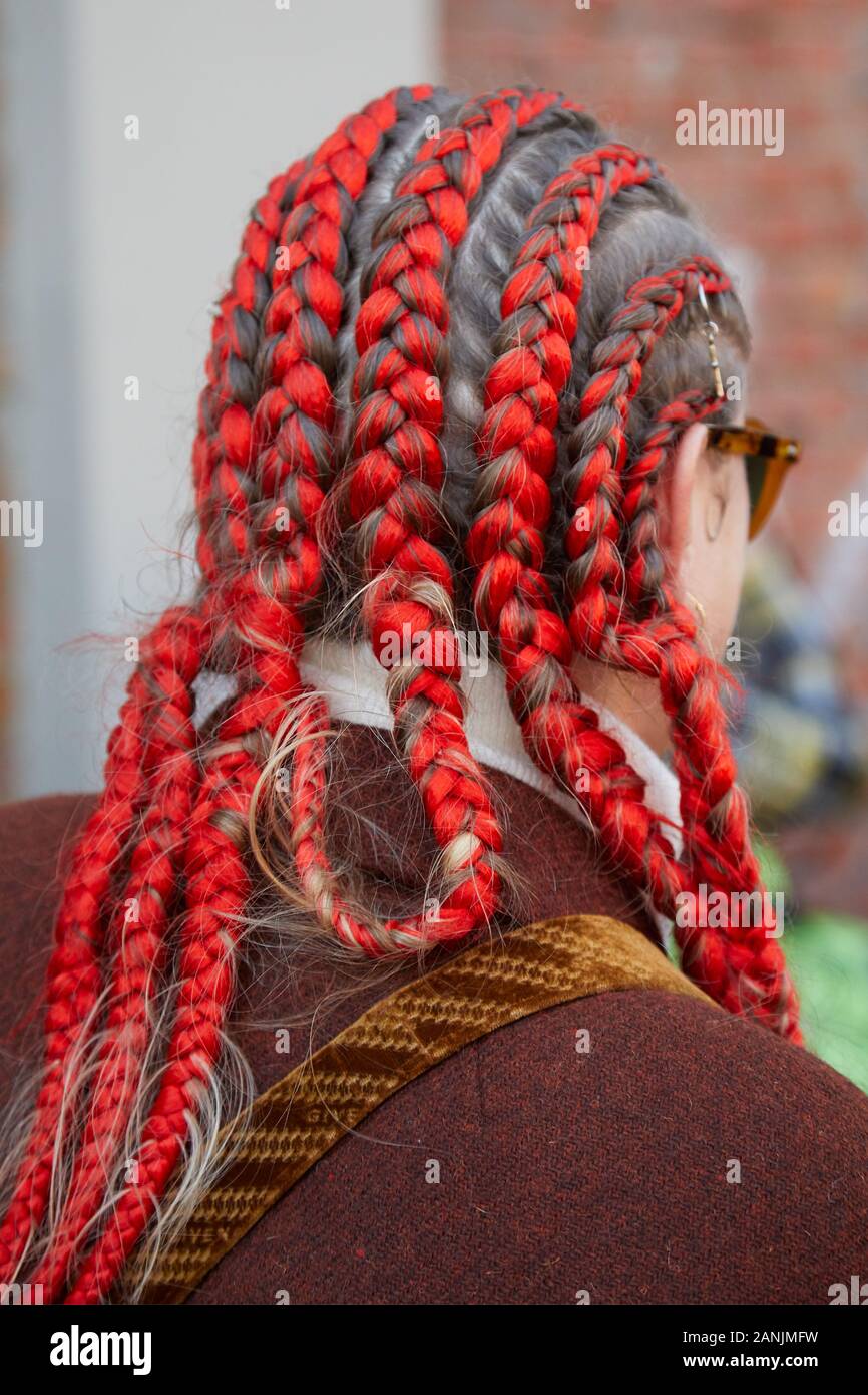MILAN, ITALY - JANUARY 13, 2019: Woman with red braids and brown jacket before Fendi fashion show, Milan Fashion Week street style Stock Photo