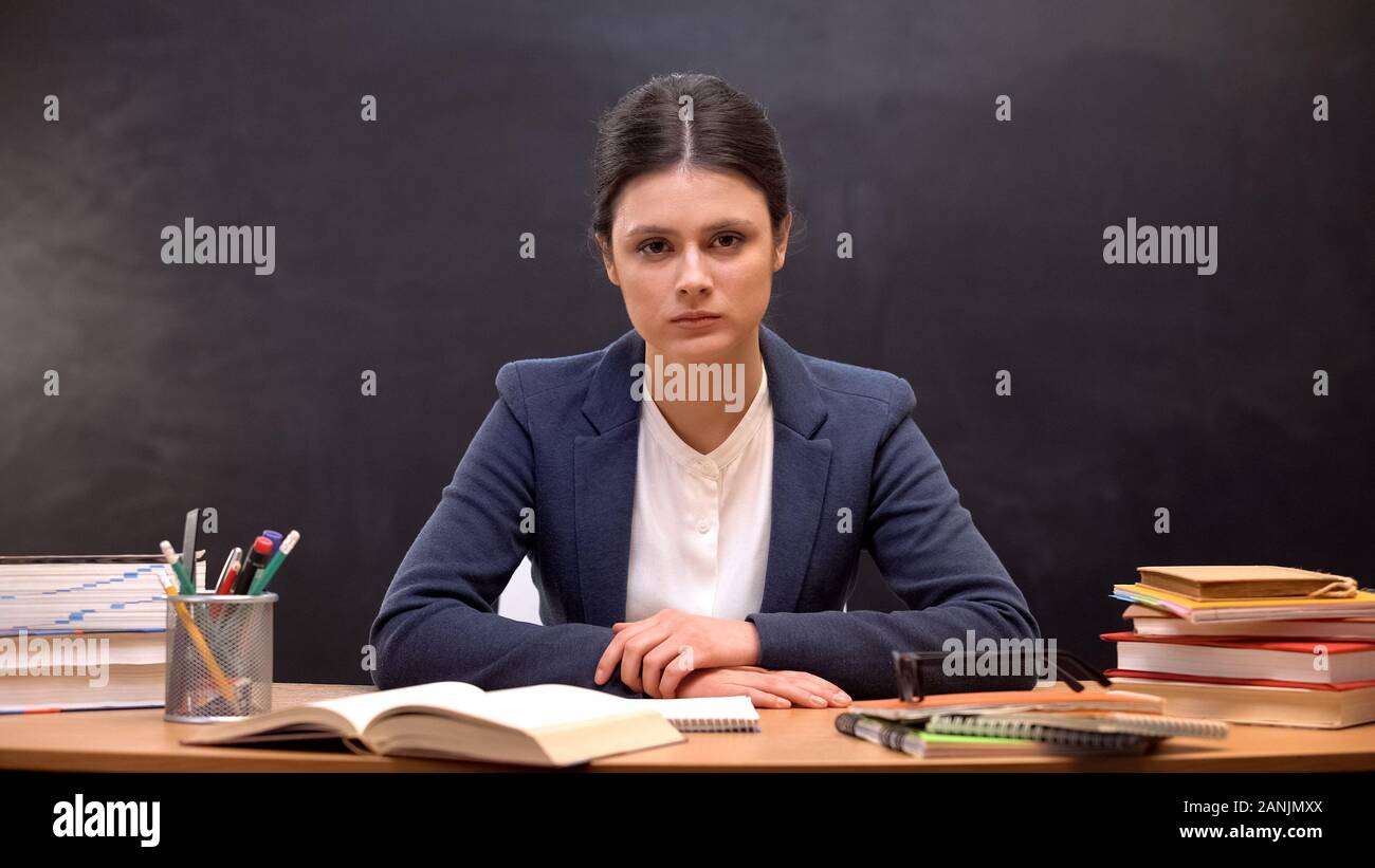 Tired overworked female teacher looking to camera, troubles at work, burnout Stock Photo